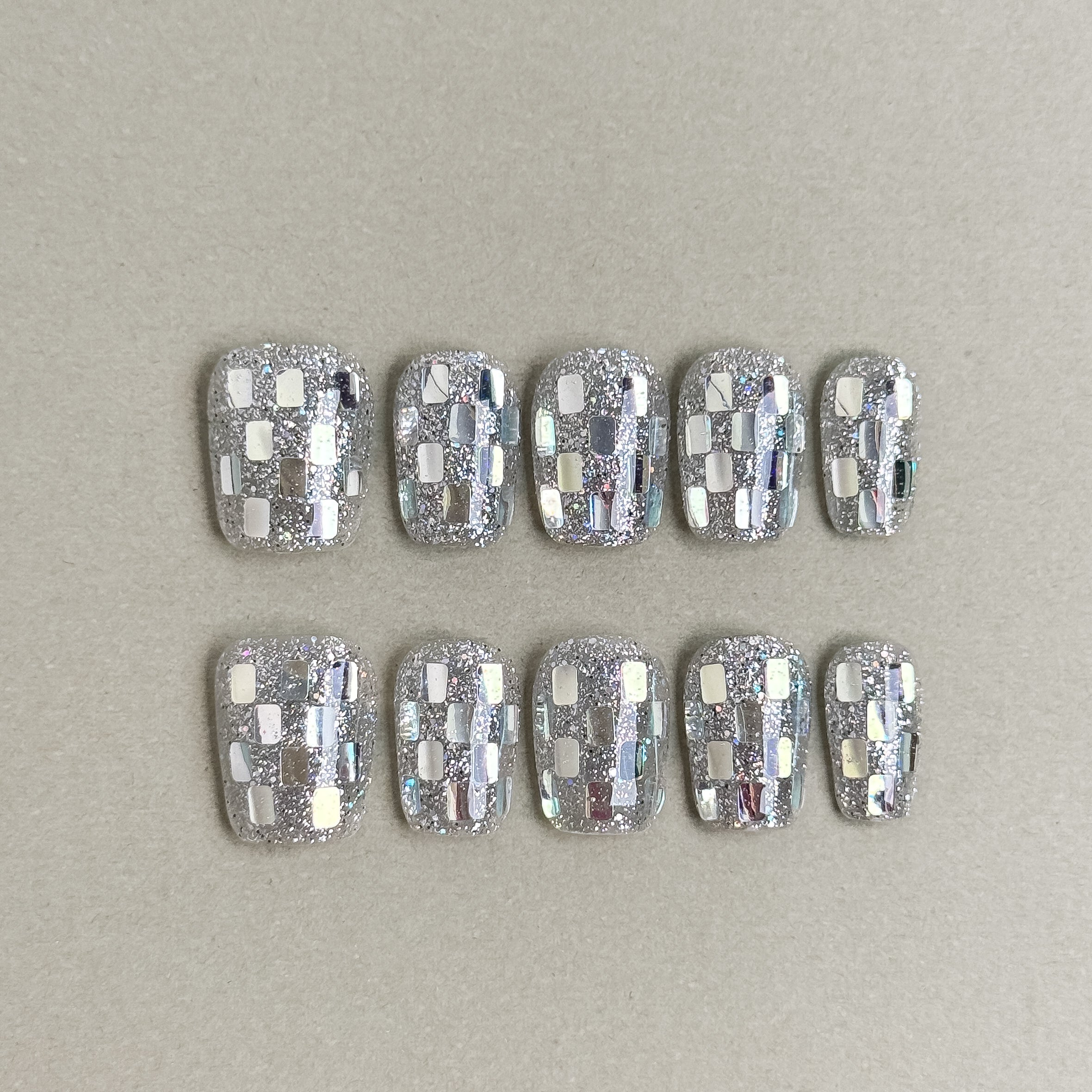 Silver chrome press-on nails with a checkered mirror effect