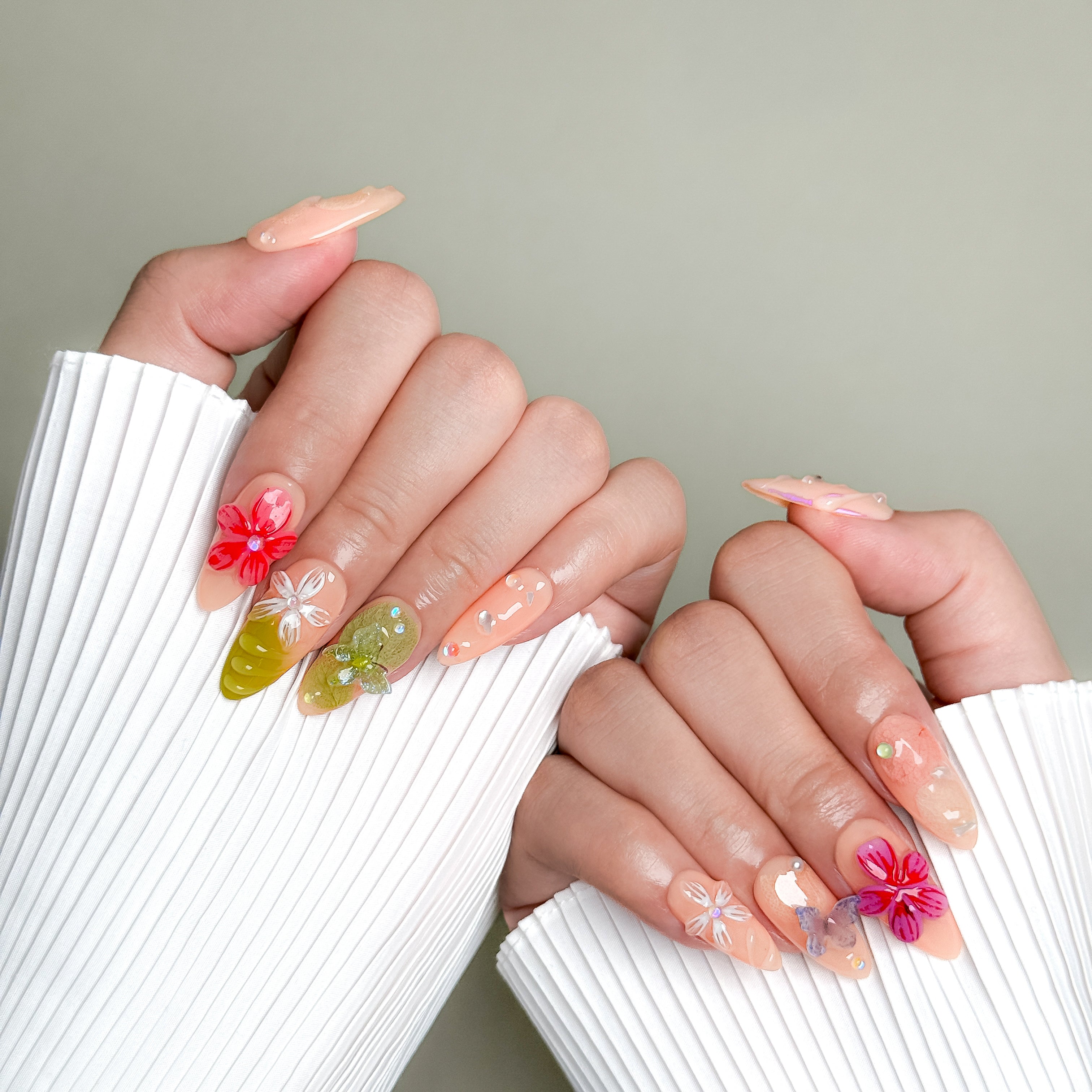 Model wearing Lost in the Garden nails with bright flower accents and glossy finish