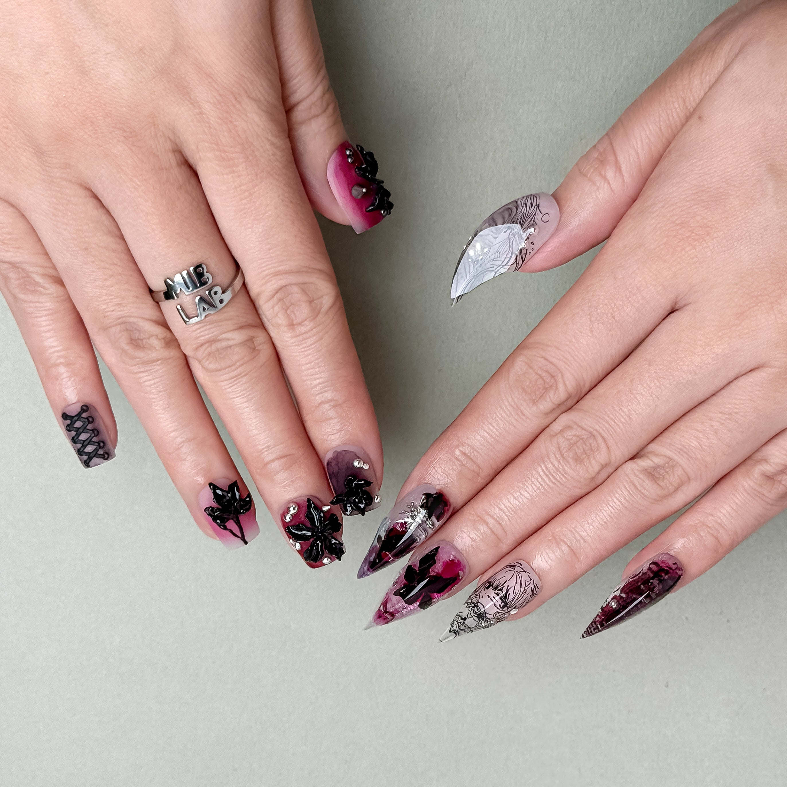 Close-up of hands highlighting the dark floral and rhinestone elements