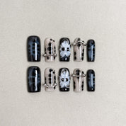 Set of reusable press-on nails in black and silver with skeleton and bone designs, MIBLAB Bones collection Geneva.