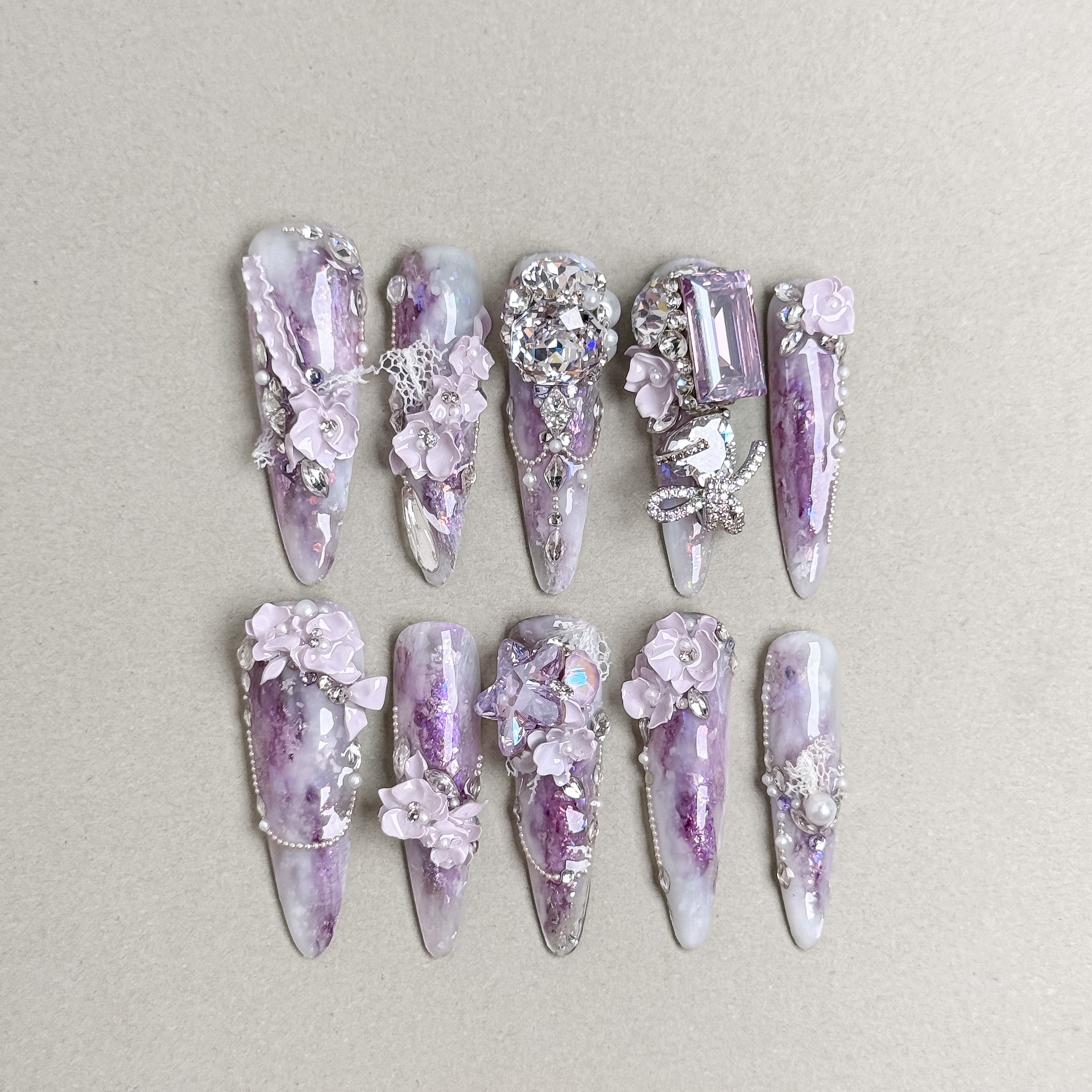 Luxury long press-on nails with lavender tones and Swarovski crystal embellishments for a glamorous finish