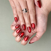 Model wearing MIBLAB Merry Me deep red glossy press-on nails, handcrafted reusable design available in Geneva.