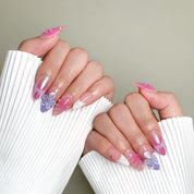 Model wearing Sun Stain nails with gradient pink tones and delicate flower details