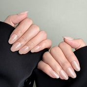 Model wearing MIBLAB You and Me nude beige glossy press-on nails, handcrafted reusable design available in Geneva.