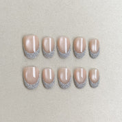 Éveil : faux ongles réutilisables nude rosé, reflets nacrés et bord argenté pailleté, press on nails premium, finition brillante.