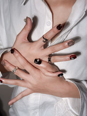 Ambre Nocturne ongles press-on artistiques ambrés et noirs portés à la main, design premium réutilisable Genève