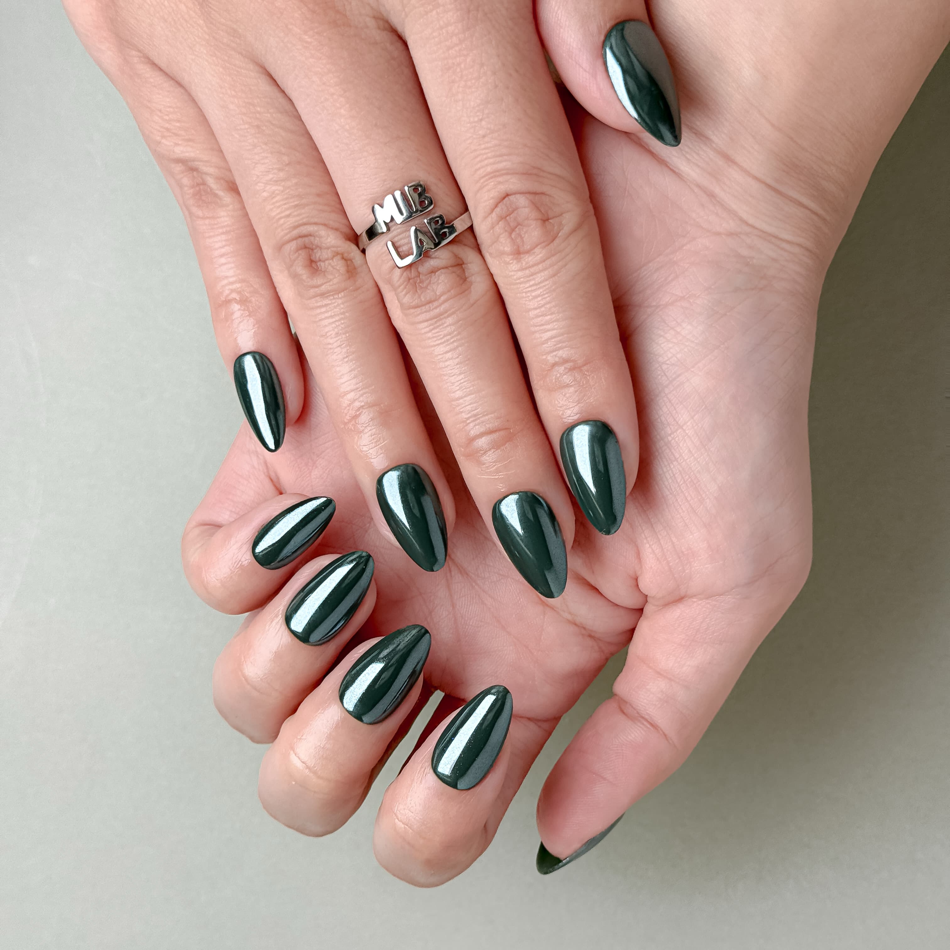 Manucure Muse portée : press on nails vert émeraude glossy, look chic et moderne, ongles sans gel, Genève.