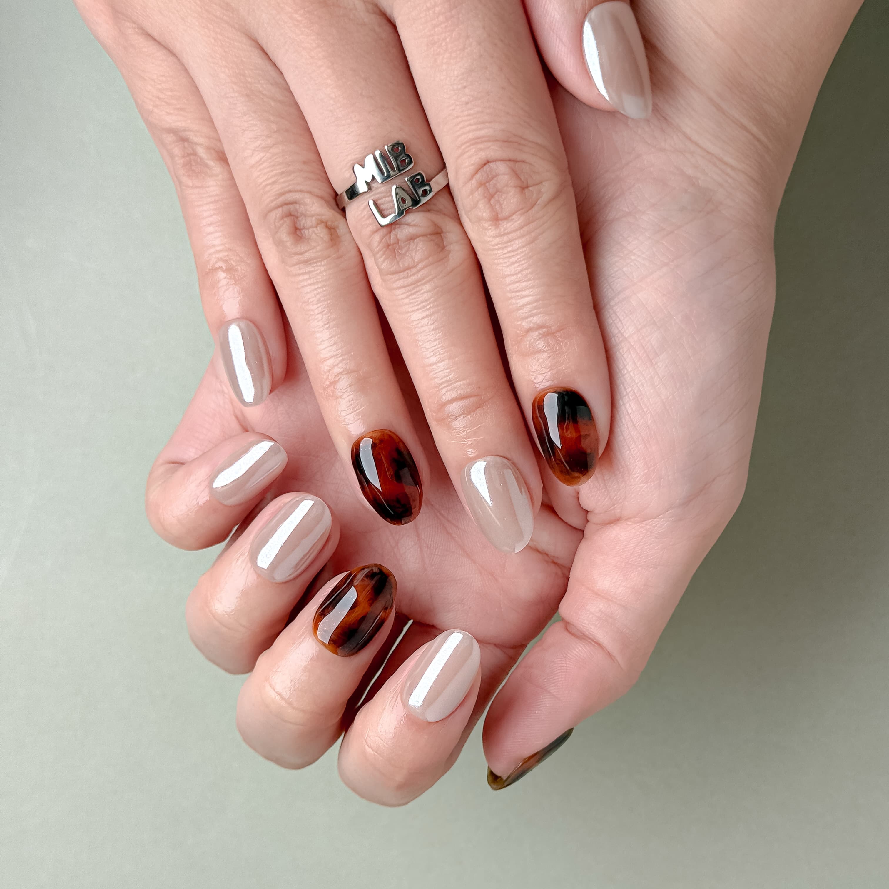 Gros plan Miss You More : faux ongles réutilisables nude laqué, accent écaille ambre, finition glossy, Suisse.