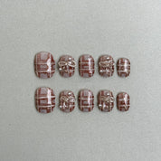 Steelé : faux ongles réutilisables nude rosé, motif quadrillé blanc type tweed, press on nails premium, finition brillante.