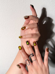 Manucure Into the Wild portée : press on nails vert olive, accents floraux, look audacieux et élégant, ongles sans gel, Genève.