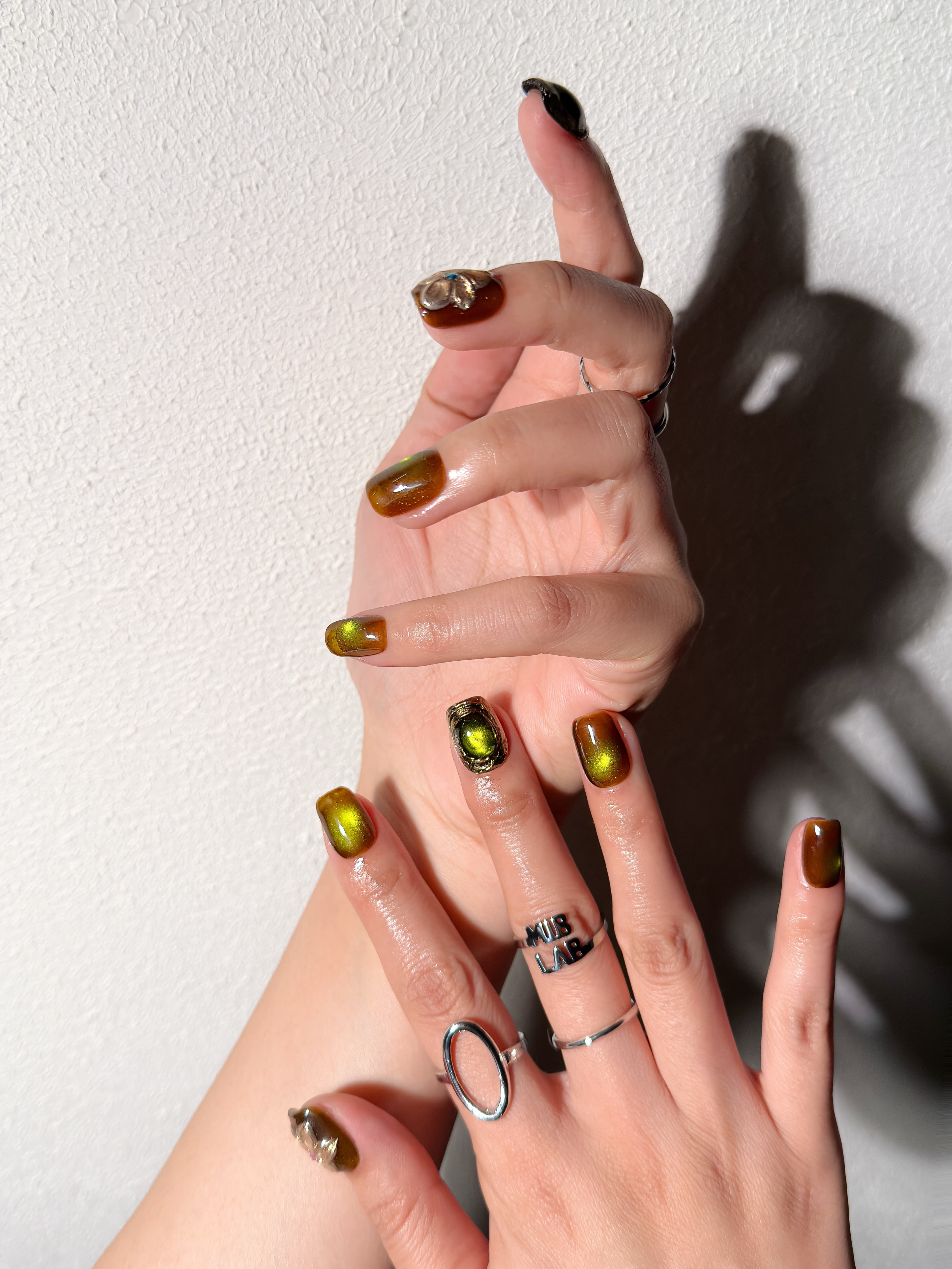 Manucure Into the Wild portée : press on nails vert olive, accents floraux, look audacieux et élégant, ongles sans gel, Genève.