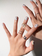 Manucure Poppy portée : press on nails blanc à pois, accent caramel avec fleur, look moderne, ongles sans gel, Genève.