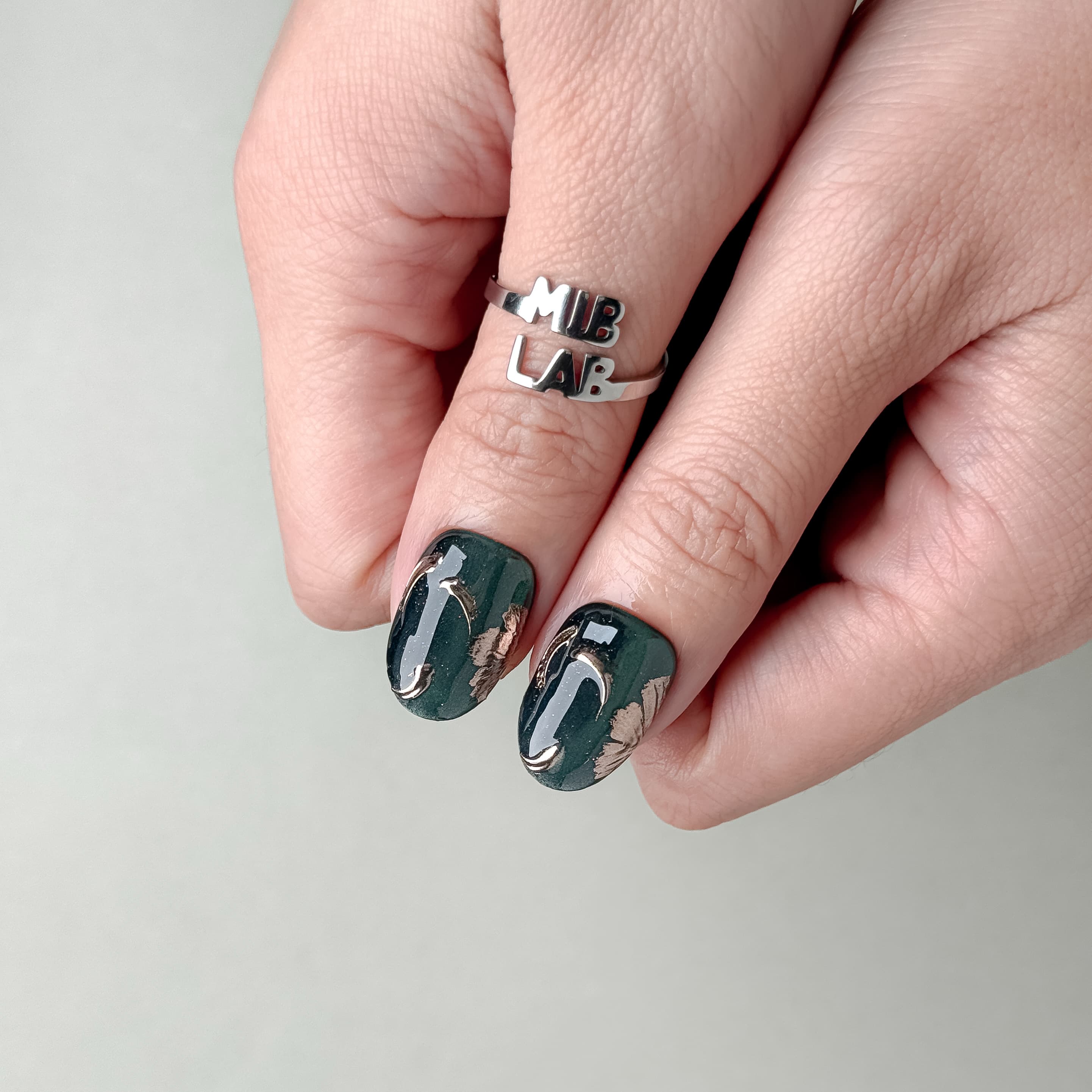 Gros plan Jade : faux ongles réutilisables vert jade marbré, touches bronze, finition glossy, Suisse.