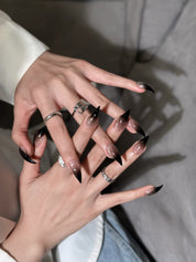 Détail Grip sur mains : faux ongles premium réutilisables dégradé noir, style soirée, tenue longue durée, Suisse.