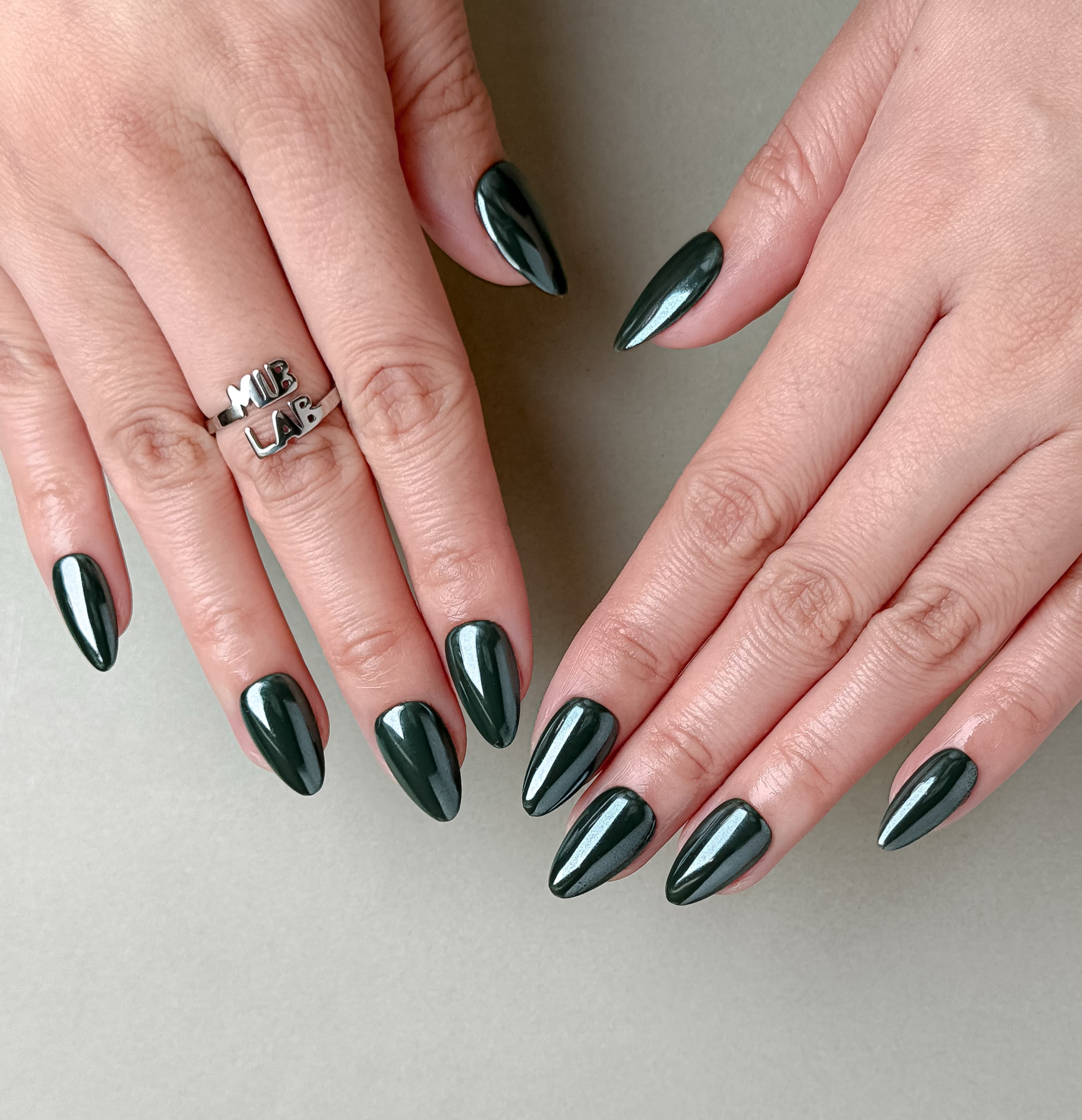 Détail Muse sur mains : faux ongles premium réutilisables vert profond, style soirée élégant, tenue longue durée, Suisse.