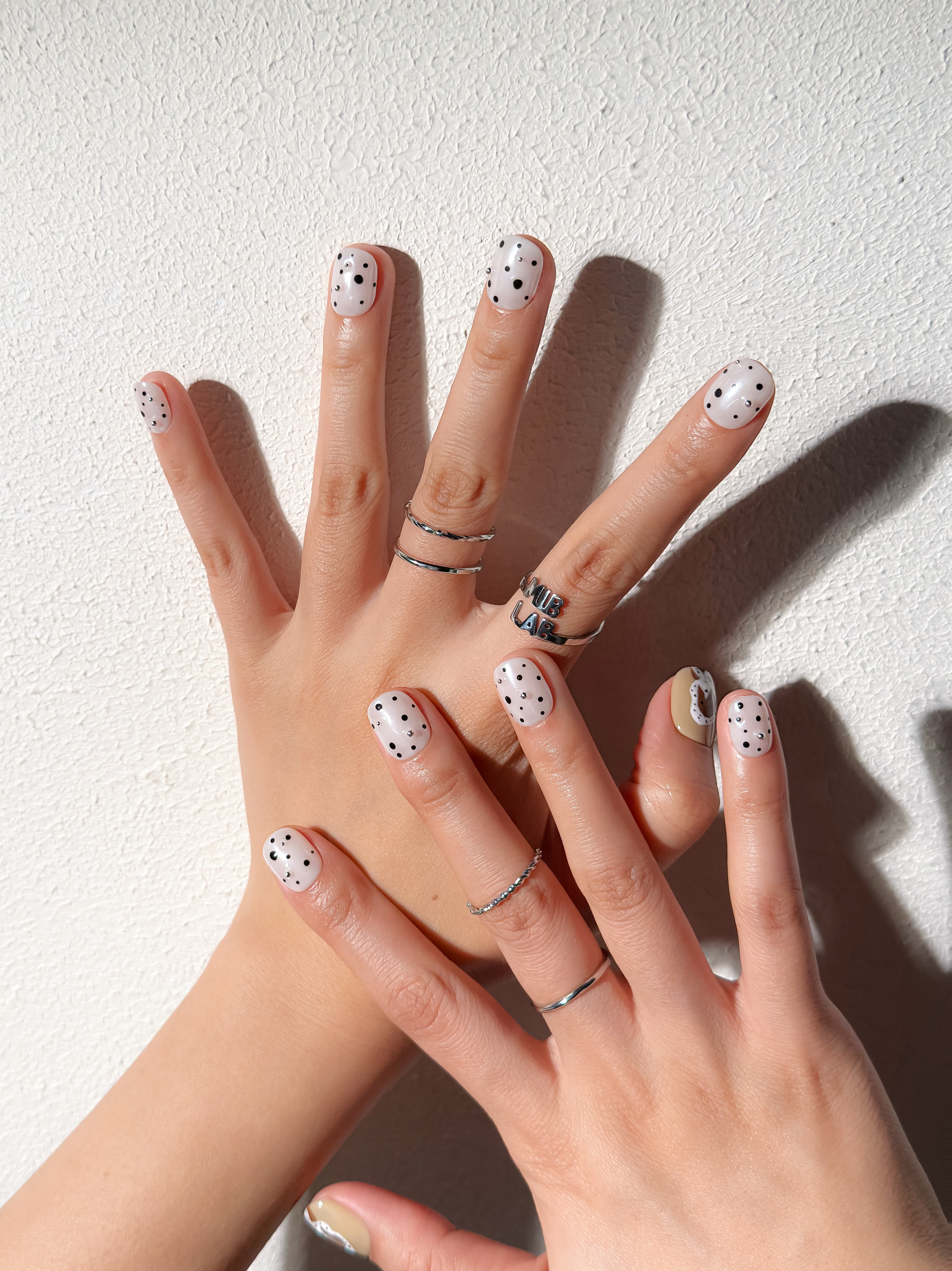 Détail Poppy sur mains : faux ongles premium réutilisables motif pois et fleur, style quotidien chic, Suisse.