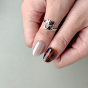Deux mains avec Miss You More : press on nails premium nude-beige, détails écaille, manucure rapide, Genève.