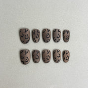Nyx : faux ongles réutilisables nude taupe avec motifs noirs abstraits, press on nails premium, finition brillante.