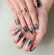 Manucure Jade portée : press on nails vert jade, détails bronze, look chic et moderne, ongles sans gel, Genève.