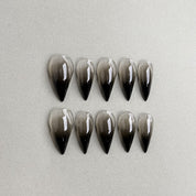 Grip : faux ongles réutilisables dégradé nude vers noir, finition glossy, forme longue stiletto, press on nails premium.